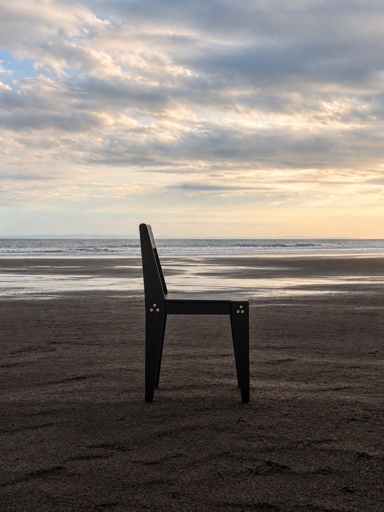 The Chair in profile on the same beach, the three-bolt clusters catching the evening light